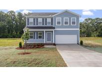 Charming two-story home with blue siding, black shutters, and a well-maintained front yard at 157 Grove Township Way, Angier, NC 27501