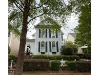 Charming two-story home featuring blue shutters and a well-manicured lawn with a white picket fence at 1703 Happiness Hill Ln, Raleigh, NC 27614