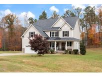Charming two-story home featuring a welcoming front porch and a well-maintained landscaped yard at 1726 Rapids Ct, Franklinton, NC 27525