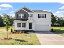 Charming two-story home with a well-manicured lawn, black shutters and a spacious two-car garage at 173 Grove Township Way, Angier, NC 27501