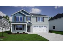 Two-story house with blue and gray siding, white garage door, and landscaping at 173 Grove Township Way, Angier, NC 27501
