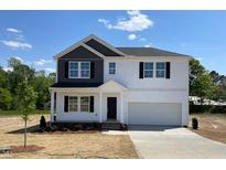 Charming two-story home with black and white accents, a two car garage and manicured landscaping at 173 Grove Township Way, Angier, NC 27501