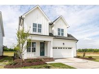 Charming two-story home featuring a white exterior, attached garage, and inviting front porch at 1813 Bright Lantern Way, Wendell, NC 27591