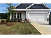 Charming single-Gathering home featuring a two-car garage, stone accents, and a well-manicured lawn at 19 E American Marigold Dr # 34, Benson, NC 27504