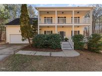 Two-story house with front porch, attached garage, and landscaping at 2010 Brass Ct, Franklinton, NC 27525