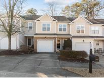 Tan brick townhome with 2-car garage and landscaping at 2118 Stoney Spring Dr, Raleigh, NC 27610