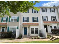 Tan three-story townhouse with teal front door and white fence at 2221 Valley Edge Dr # 105, Raleigh, NC 27614