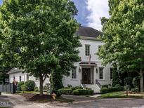 Stately two-story brick home featuring an American flag, manicured landscaping and a charming entrance at 2900 Glenanneve Pl, Raleigh, NC 27608