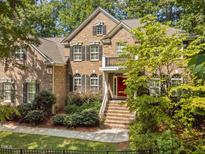 Charming two-story brick home with black shutters, manicured landscaping, and welcoming front entrance at 327 Davis Love Dr, Chapel Hill, NC 27517