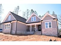 Beautiful single-Gathering home with stone accents, gray siding, and a black shingle roof at 3925 Cedar Knolls Dr, Youngsville, NC 27596