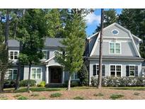 Charming gray two-story home with a well-manicured lawn and mature trees, perfect for a Gathering at 4201 Henderson Pl, Pittsboro, NC 27312