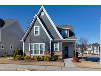 Charming two-story home with gray siding and stone accents at 501 Old Ride Drive, Holly Springs, NC 27540