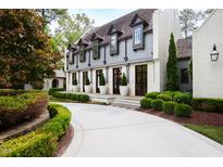 Elegant two-story home with a gray and white exterior, circular driveway, and landscaping at 805 Pinehurst Dr, Chapel Hill, NC 27517