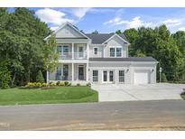 Stunning two-story home featuring a double-decker porch, well-manicured lawn, and a spacious three car garage at 125 Charlotte Knoll St # 15, Zebulon, NC 27597
