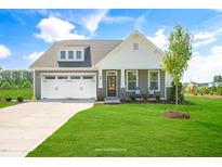 Charming home with a well-manicured lawn, attached two-car garage, covered front porch, and inviting curb appeal at 116 Charlotte Knoll St # 7, Zebulon, NC 27597