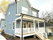 Two-story house with gray siding, white porch, and red door at 1208 Gearwood Ave, Durham, NC 27701