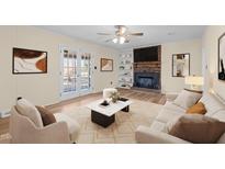 Bright living room featuring a fireplace, white sofas, a ceiling fan, and stylish decor at 1219 Carlton Ave, Burlington, NC 27217