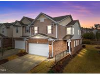 Charming townhome with brick facade, two-car garage, and well-manicured landscaping at 1700 Cary Reserve Dr, Cary, NC 27519