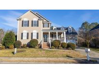 Charming two-story home with manicured lawn, inviting front porch, and traditional architectural details at 30155 Pharr, Chapel Hill, NC 27517