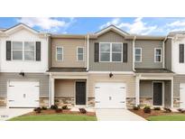 Three-unit townhome building with gray and beige siding, two-car garages, and landscaping at 422 Honeycutt Oaks Dr, Angier, NC 27501