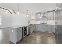 Modern kitchen boasts gray cabinets, stainless appliances, a wine cooler, and pendant lighting over the island at 520 S Bloodworth St, Raleigh, NC 27601