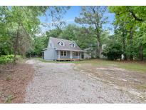 Charming home featuring a gravel driveway and inviting covered front porch at 621 Shepard School Rd, Zebulon, NC 27597