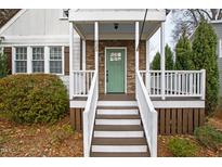 Inviting front porch with charming green door and stone accents at 625 New Road Rd, Raleigh, NC 27608