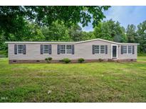 Tan mobile home with black shutters and a spacious lawn at 95 Old Barn Ct, Rocky Mount, NC 27801