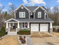 Two-story home with gray siding, white trim, and a two-car garage at 101 Pointe Park Cir, Holly Springs, NC 27540