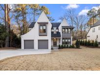 Two-story home with white brick, gray accents, and a two-car garage at 1304 Ivy Ln, Raleigh, NC 27609