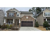 Two story home featuring a stone-clad garage and inviting front porch at 206 Kanewind Ter, Apex, NC 27523