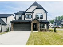 Charming two-story home boasts a stone-accented entrance and a two-car garage at 3284 Roundly Rd # 16, New Hill, NC 27562