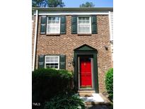 Brick townhouse with red front door, green shutters, and landscaping at 6369 New Market Way, Raleigh, NC 27615