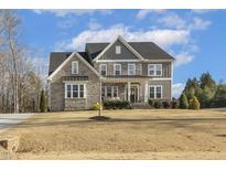 Beautiful two-story home featuring a stone and siding exterior with a covered front porch at 1625 Banks View Dr, Raleigh, NC 27603
