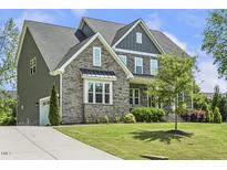 Stunning two-story home features stone accents, gray siding, well-manicured lawn and a welcoming driveway at 1625 Banks View Dr, Raleigh, NC 27603