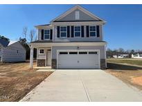 Charming two-story home featuring a covered front porch and a spacious two-car garage, perfect for modern living at 200 Wild Turkey Way Way, Lillington, NC 27546