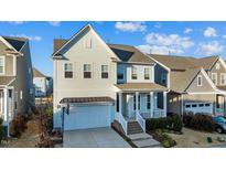 Charming two-story home with a welcoming front porch and attached two-car garage at 413 Holding Creek Dr, Wake Forest, NC 27587