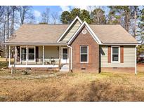Brick and shingle ranch home with covered porch and landscaped yard at 521 N Franklin Dr, Sanford, NC 27330