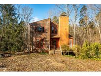 Two story home with wood siding, large deck and chimney at 5701 Cascade Dr, Chapel Hill, NC 27514