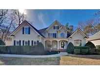 Two-story house with light beige siding, black shutters, and a manicured lawn at 5911 Brushy Meadows Dr, Fuquay Varina, NC 27526