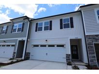 New construction townhouse featuring white siding, a two-car garage and decorative black shutters at 7117 Hubner Pl # 22, Cary, NC 27519