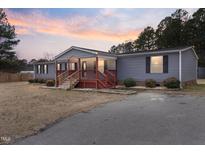 Ranch-style home with gray siding, red accents, and a covered porch at 7228 Pecan Tree St, Willow Springs, NC 27592