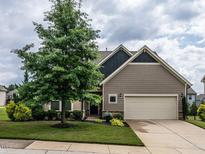 Charming single-Gathering home with a two-car garage and a beautifully landscaped front yard and mature tree at 13 Needham Ln, Clayton, NC 27527