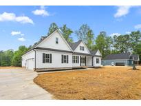 Beautiful white farmhouse-style home with black shutters, a spacious driveway, and a well-manicured lawn at 250 Ellington Rd, Graham, NC 27253