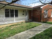 Charming home featuring a cozy front porch and a combination of siding and brick exterior at 306 Eastway Ln, Graham, NC 27253