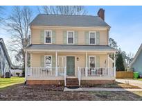 Two story home with light beige siding, white trim, and front porch at 7120 Sandringham Dr, Raleigh, NC 27613
