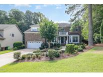 Beautiful two-story brick home with manicured landscaping, two-car garage and a welcoming front entrance at 101 Quarryrock Rd, Holly Springs, NC 27540