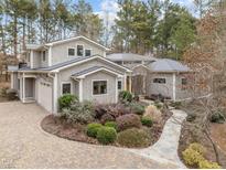 A beautiful exterior elevation of the gray shingled home featuring professional landscaping at 114 Spring Blossom Ln, Durham, NC 27705