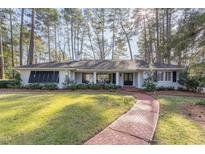 White charming house with brick pathway, surrounded by lush green trees at 2801 Chelsea Cir, Durham, NC 27707