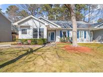 Gray house with blue shutters, landscaped yard, and a tree in the front at 3125 Quinley Pl, Raleigh, NC 27604